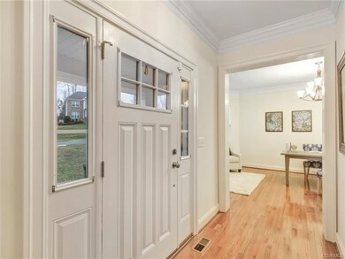 Bright foyer with wood floors and crown detail.