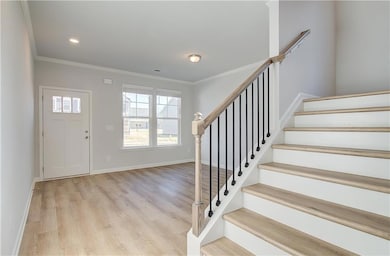 Foyer entrance featuring light wood-type flooring and ornamental molding
