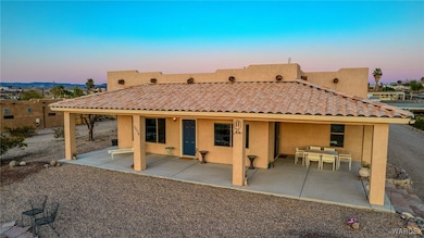 Back of property featuring a patio area, stucco siding, a tiled roof, and outdoor dining area