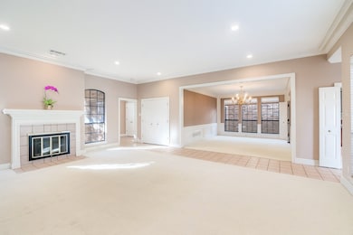 Spacious living room with gorgeous crown molding, a gas fireplace, recessed lighting and opening up to the dining room.