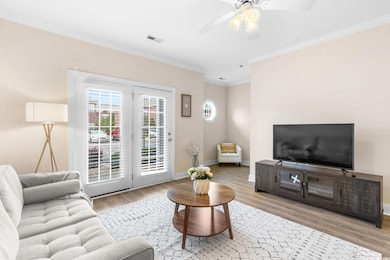 Living area with ornamental molding, a ceiling fan, and wood finished floors