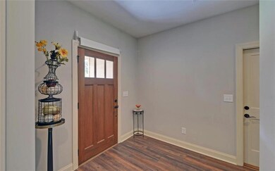 Foyer with dark wood-style flooring and baseboards