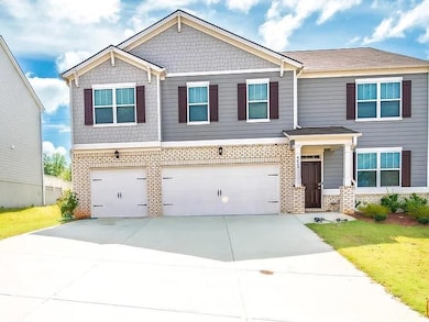 Craftsman house with brick siding, concrete driveway, an attached garage, and a front lawn