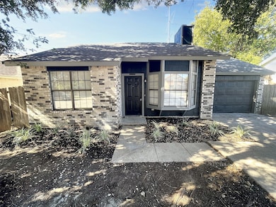 Ranch-style house featuring roof with shingles, brick siding, an attached garage, and a chimney