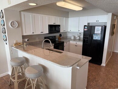 Kitchen with light stone counters, white cabinetry