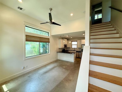 Unfurnished living room with concrete floors, sta