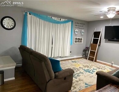 Living area featuring a baseboard radiator, wood f