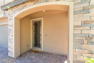 Doorway to property featuring stone siding and a g