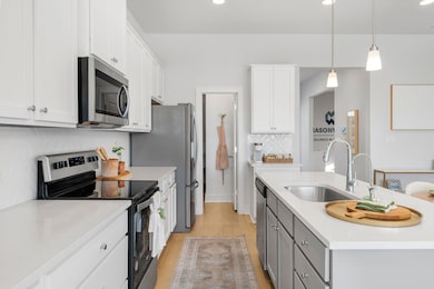 Kitchen with backsplash, a sink, light countertop