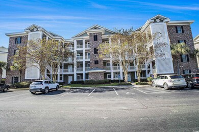 View of apartment building / complex with uncovered parking