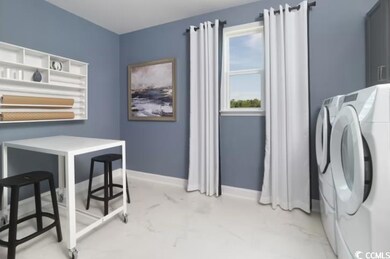 Washroom featuring washer / clothes dryer, baseboards, and light marble finish flooring