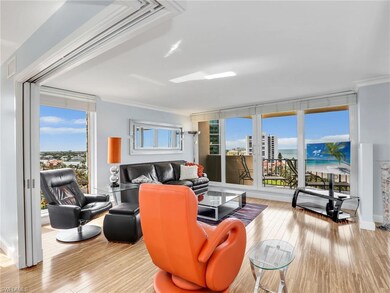 Living room featuring hardwood / wood-style flooring, ornamental molding, and a wall of windows
