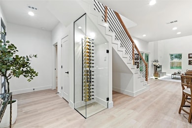 Wine area featuring baseboards, light wood-style f