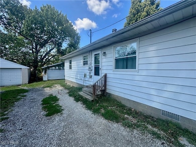 View of front of property with an outdoor structure and a detached garage