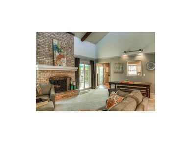 Vaulted ceilings & warm brick fireplace in spaciou