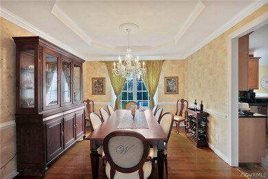 Beautiful Formal Dining Room with Hardwood Floors, Tray Ceiling, Crown and Chair Moldiing, and Stunning Crystal Chandelier