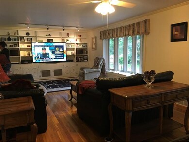 Living Room With Hardwood Flooring, Built Ins & Ba