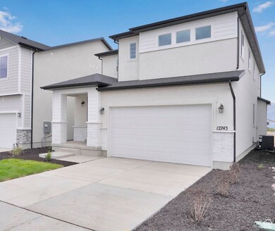 View of front of property with a garage, stucco siding, driveway, and stone siding