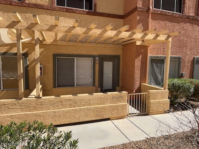 Property entrance with a pergola and stucco siding