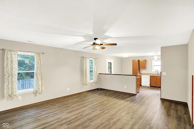 unfurnished living room with ceiling fan and dark wood finished floors