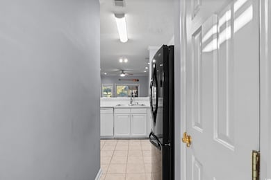 Hall with light tile patterned floors and a textured ceiling