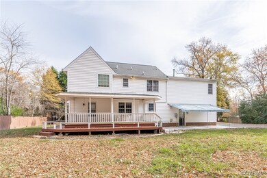 Back of house featuring a yard, a deck, and a pati