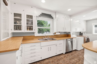 Kitchen featuring washing machine and dryer, plenty of natural light, light countertops, dishwasher, and recessed lighting