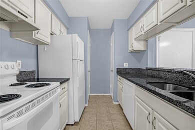 The kitchen has black and grey granite countertops