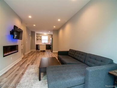 Living area featuring recessed lighting, a glass covered fireplace, and light wood finished floors