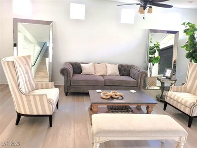 Living area featuring a ceiling fan and wood finis