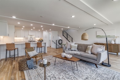 Living room with recessed lighting, light wood-type flooring, and stairs