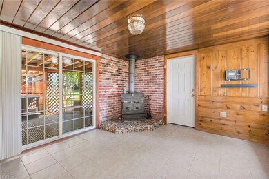 dining space with wood ceiling, a wood stove, ligh
