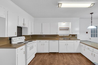 Kitchen featuring hanging light fixtures, white ca