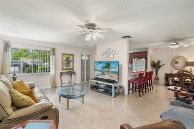 Living room featuring ceiling fan, light tile patt
