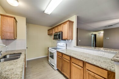 Kitchen with white electric range, light stone cou