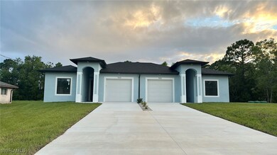 View of front facade featuring a garage and a yard