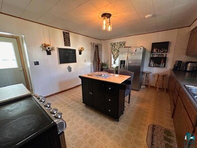 Kitchen featuring stainless steel refrigerator with ice dispenser, dark cabinetry, and a center island