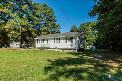View of front of home featuring a front lawn and an outbuilding