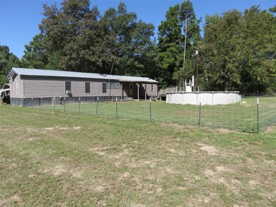 Rear view of 18x76 Manufactured home. Fence and pool not included in sale at this time.