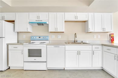 Kitchen with white appliances, light countertops,