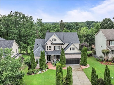 View of front of house featuring concrete driveway, a front lawn, a porch, and an attached garage