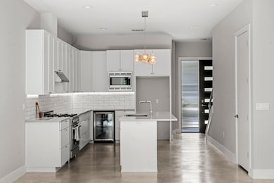 Kitchen featuring backsplash, hanging light fixtu