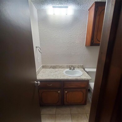 Bathroom with vanity, toilet, and tile patterned f