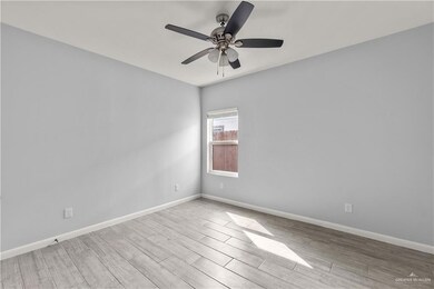 Spare room with wood finished floors, baseboards, and ceiling fan