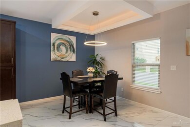 Tiled dining room featuring a notable chandelier and a tray ceiling