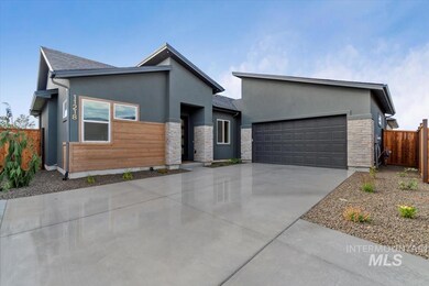 Contemporary home featuring stone siding, driveway, stucco siding, and an attached garage
