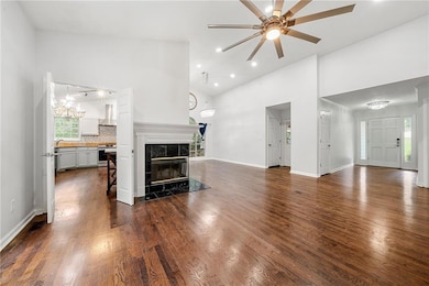 Living Room with Vaulted Ceilings, Recessed Lighting, Ceiling Fan, Glass-Covered Fireplace, and Wood-Finished Floors