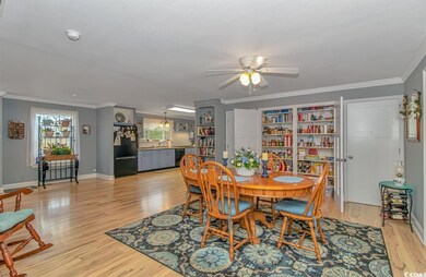 Dining space with ornamental molding, light hardwo