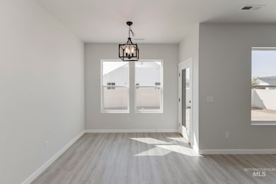 Unfurnished dining area featuring light wood finished floors and a chandelier