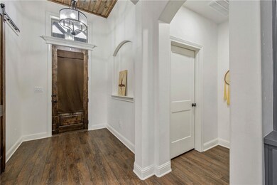 Entryway with  wood-type flooring, arched walkways